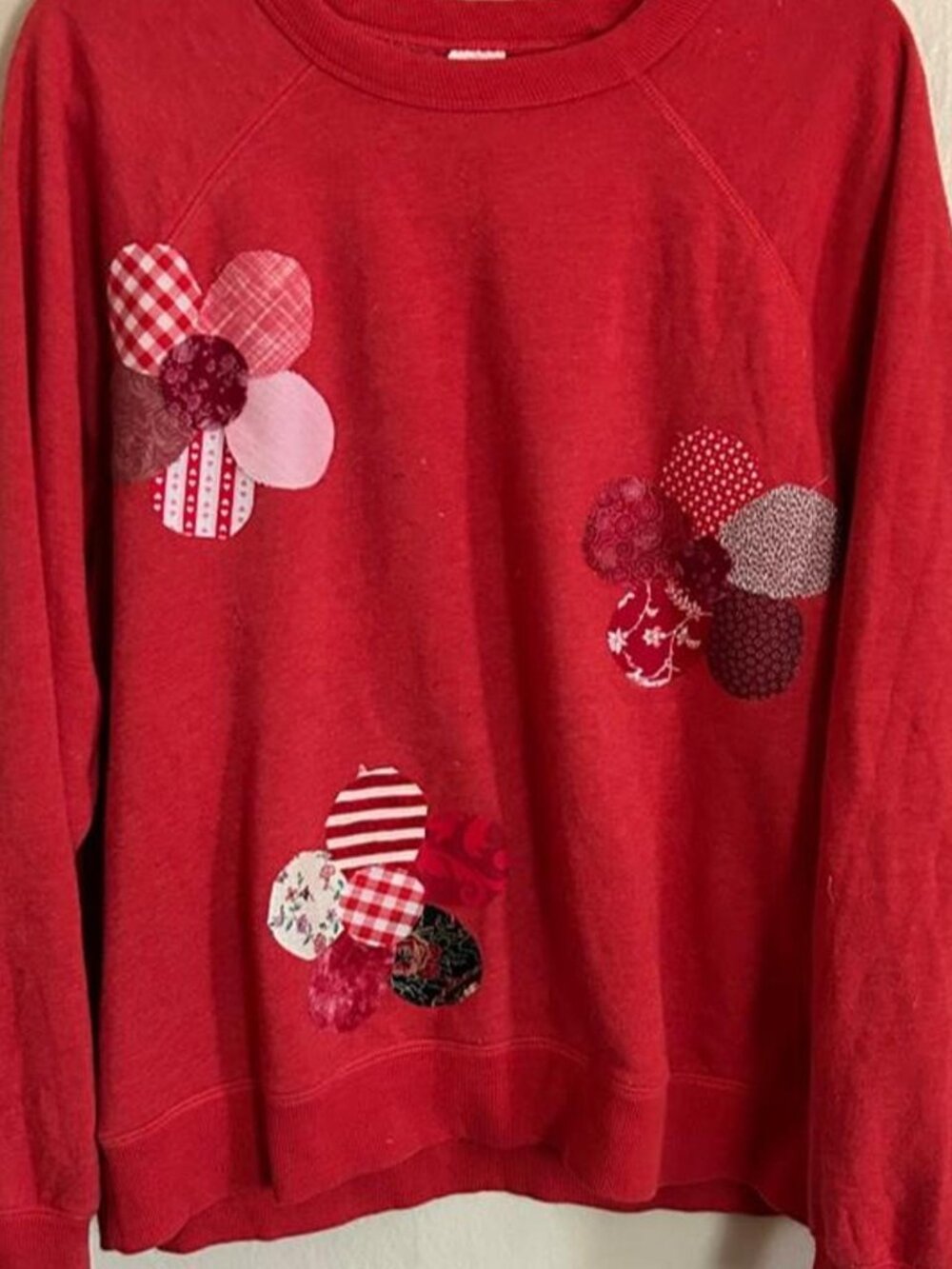 Cozy red sweatshirt decorated with clusters of colorful vintage-inspired fabric